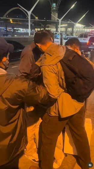 一名在现场自报姓名为「Jing Zhao」的华人女子，在机场航站楼外被多名便衣人员控制并带上一辆白色厢型车。面对旁人的追问，现场人员确认自己属于美国移民与海关执法局（ICE），并称带走女子的原因是「违反移民规定」。（IG@veganchefchristucker影片截图）