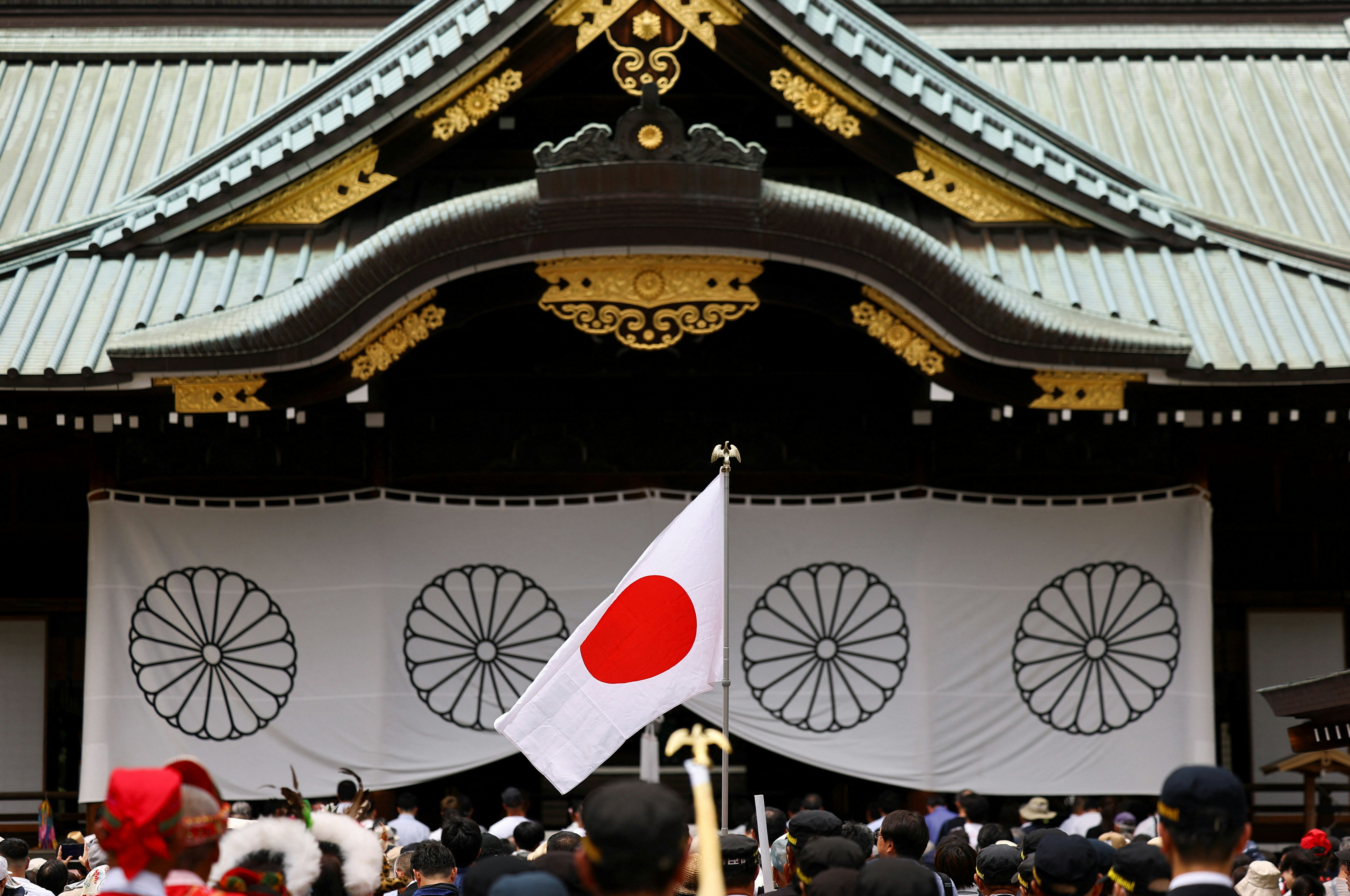 2026年8月15日，日本东京，一面日本国旗迎风飘扬，民众前往靖国神社祭拜二战死难者，纪念日本在二战中投降81周年。（Reuters）