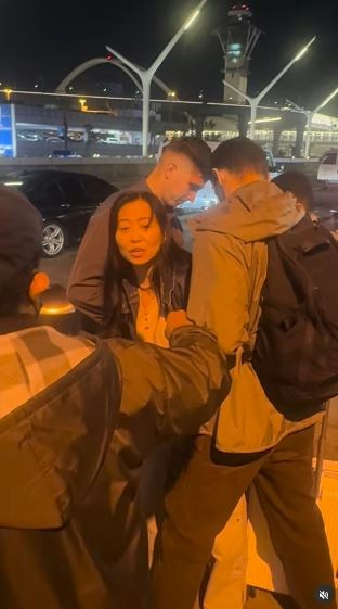 一名在现场自报姓名为「Jing Zhao」的华人女子，在机场航站楼外被多名便衣人员控制并带上一辆白色厢型车。面对旁人的追问，现场人员确认自己属于美国移民与海关执法局（ICE），并称带走女子的原因是「违反移民规定」。（IG@veganchefchristucker影片截图）