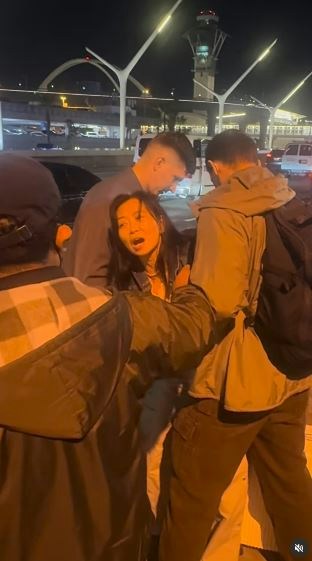 一名在现场自报姓名为「Jing Zhao」的华人女子，在机场航站楼外被多名便衣人员控制并带上一辆白色厢型车。面对旁人的追问，现场人员确认自己属于美国移民与海关执法局（ICE），并称带走女子的原因是「违反移民规定」。（IG@veganchefchristucker影片截图）