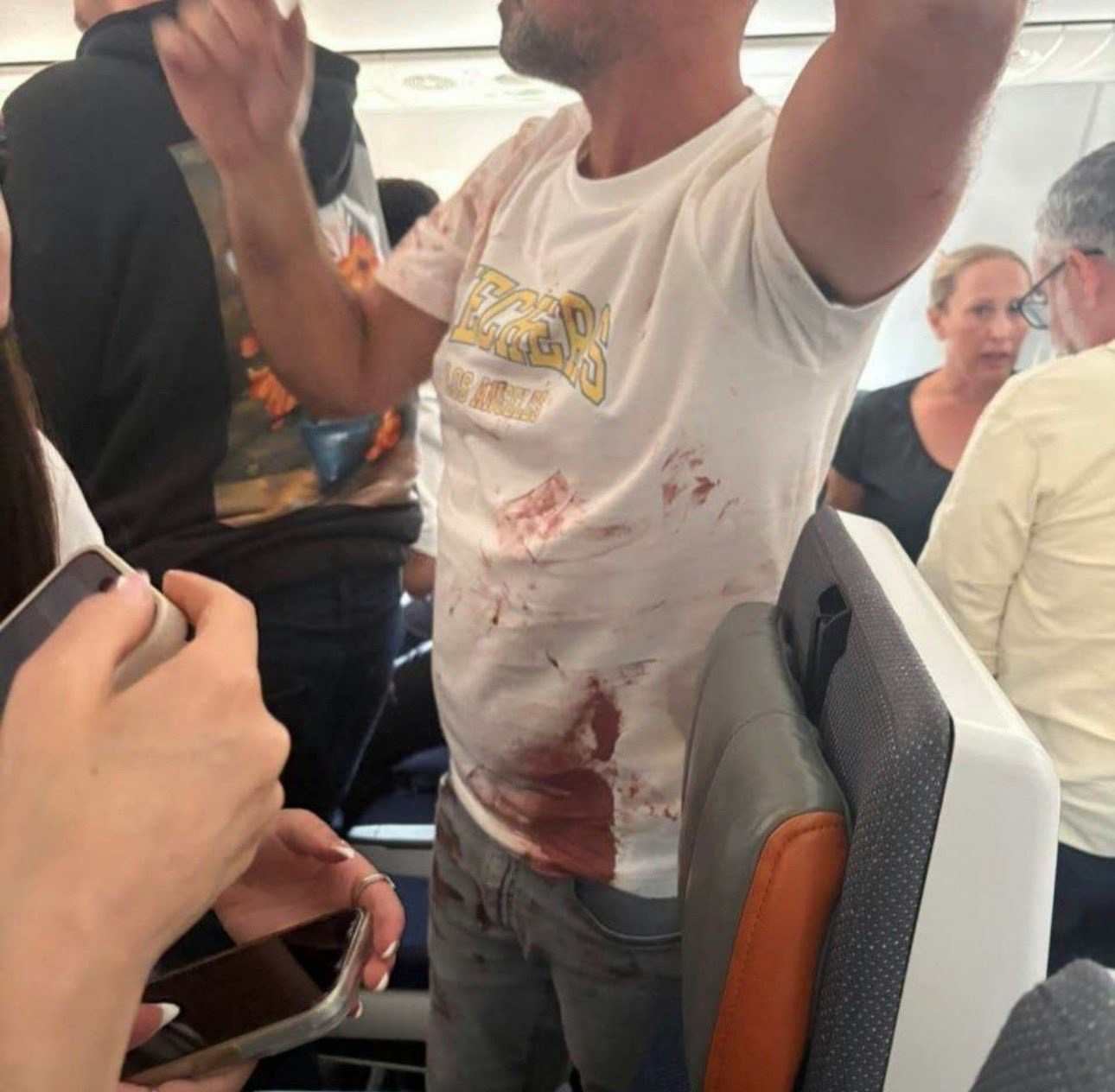 杜拜航空客机惊魂：事件中部份乘客协助制服施袭者，现场图片可见有乘客身上染血（影片截图）