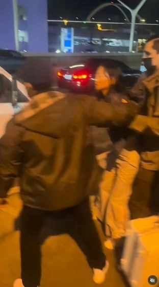 一名在现场自报姓名为「Jing Zhao」的华人女子，在机场航站楼外被多名便衣人员控制并带上一辆白色厢型车。面对旁人的追问，现场人员确认自己属于美国移民与海关执法局（ICE），并称带走女子的原因是「违反移民规定」。（IG@veganchefchristucker影片截图）