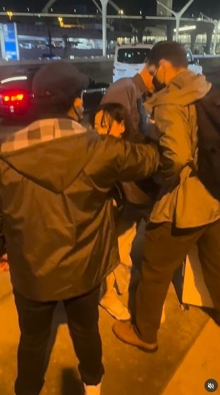一名在现场自报姓名为「Jing Zhao」的华人女子，在机场航站楼外被多名便衣人员控制并带上一辆白色厢型车。面对旁人的追问，现场人员确认自己属于美国移民与海关执法局（ICE），并称带走女子的原因是「违反移民规定」。（IG@veganchefchristucker影片截图）