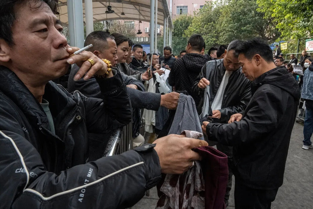 在广州的一个劳动力市场，带着服装样品的工厂老板们正在招募服装工人。 Gilles Sabrié for The New York Times