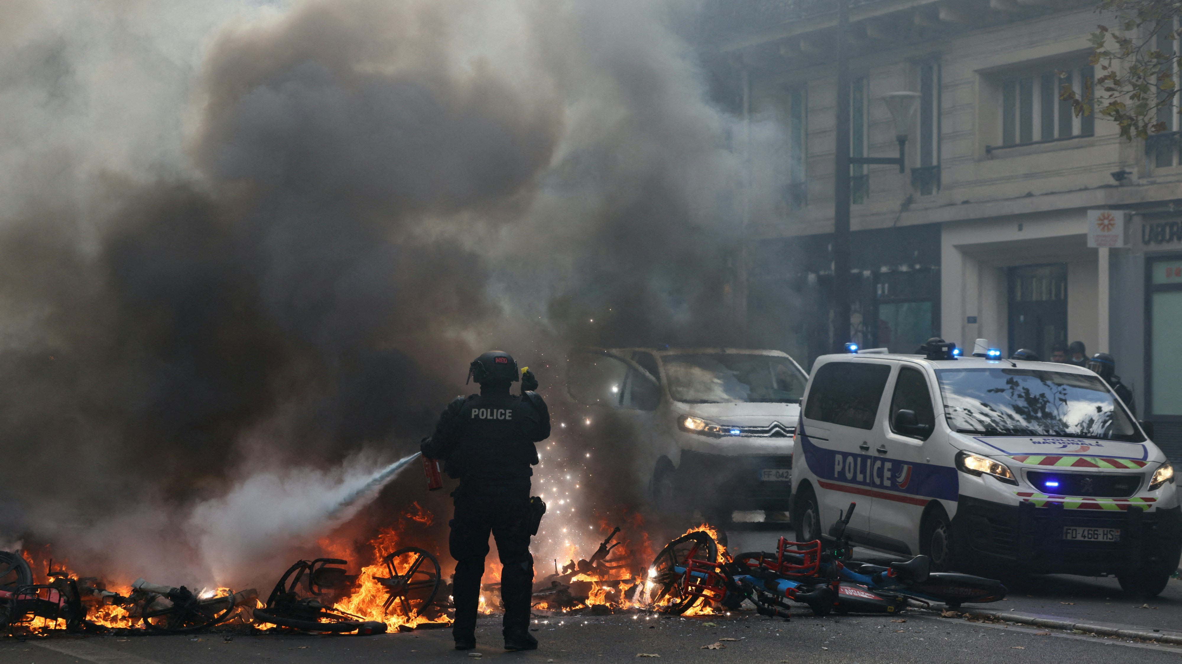 2026年10月17日，法国巴黎，一名法国警员尝试扑灭正在燃烧的自行车。当时，由「黄背心」运动发起的全国性抗议活动正在进行，旨在反对高昂的生活成本和不断上涨的燃料价格。（Reuters）